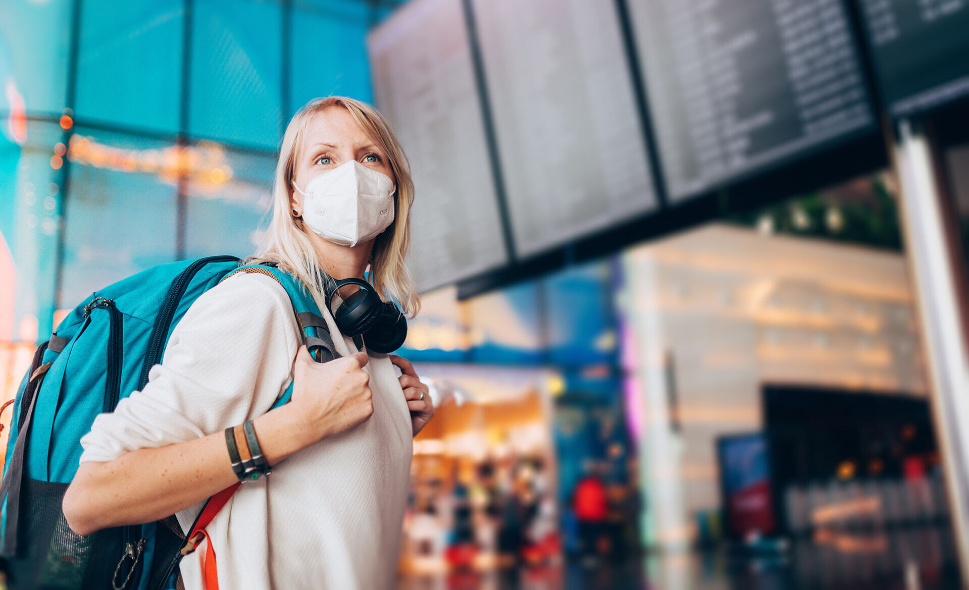 Junge Frau mit Maske am Flughafen
