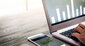 Handydisplay und Laptop mit Diagrammen 