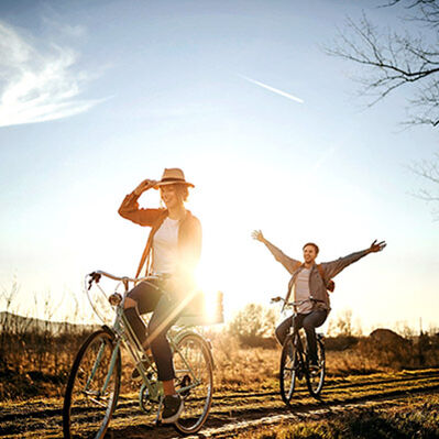 Ein Mann und eine Frau fahren bei Sonnenschein Fahrrad 