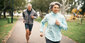 Eine Frau und ein Mann joggen im Park