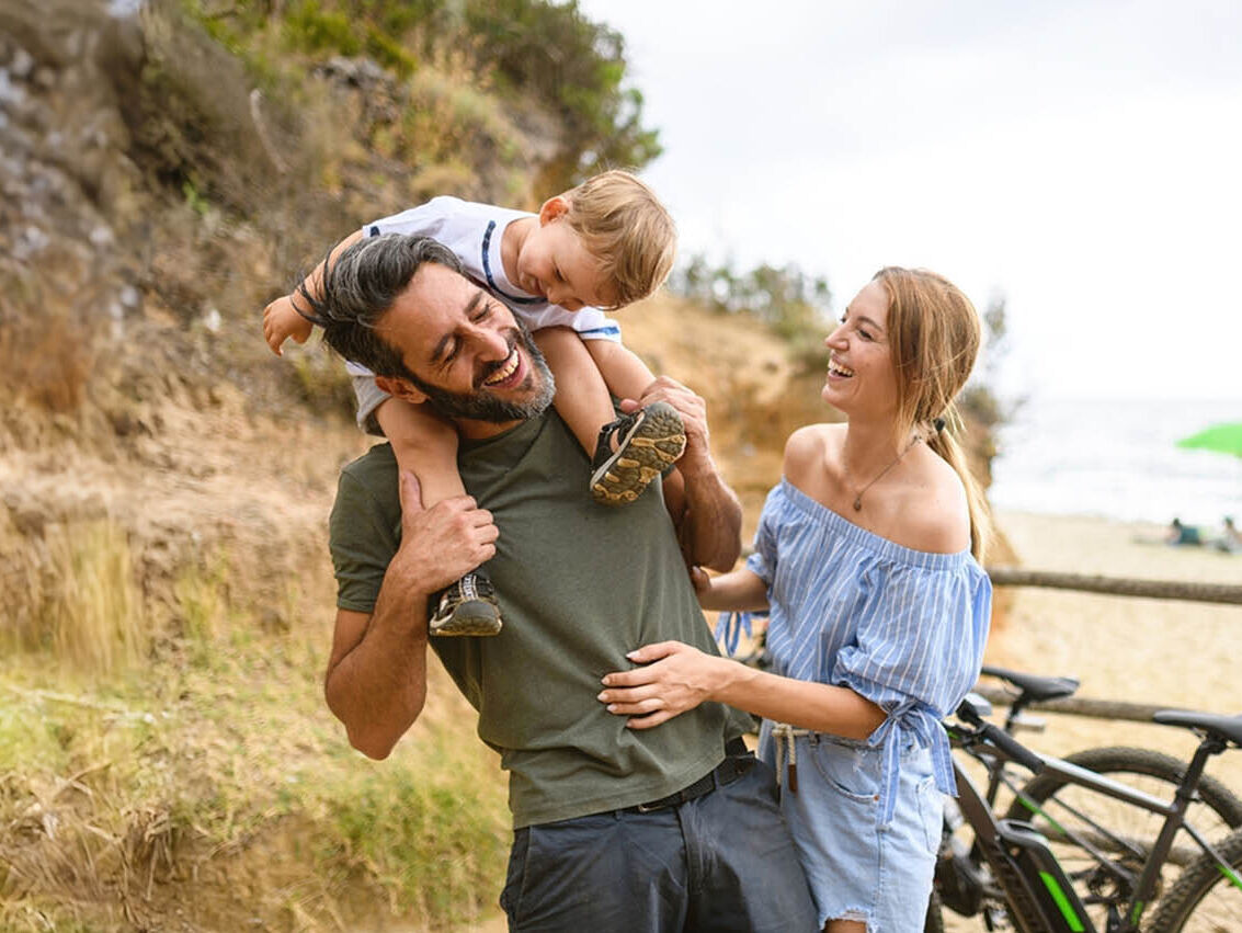 Familie mit Kleinkind mit E-Bike in der Toskana in Strand, Italien